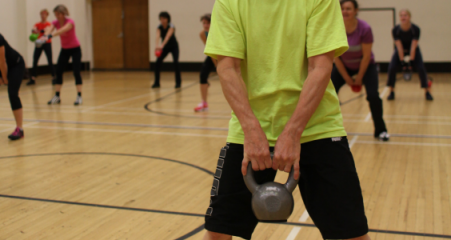 Mies nostaa kahvakuulaa kansalaisopiston liikuntatunnilla.