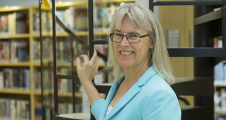 Väitöskirjantekijä Leea Keto kirjastossa.